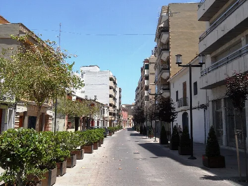 Straße mit Gebäuden und Topfpflanzen in Alacuás.