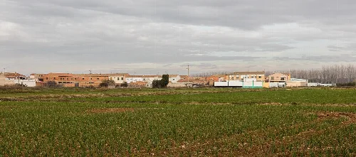 Earth-colored houses and green field in Boquiñeni, Zaragoza.