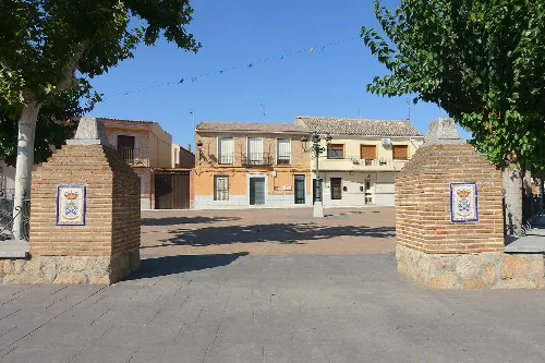 Entrance to the Plaza de la Constitución with brick walls and decorative tiles.