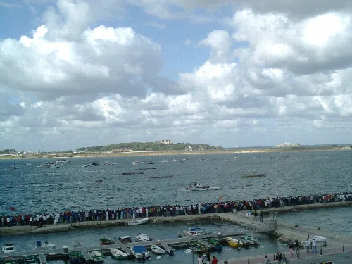 Barcos de regata en la bahía de Santander con espectadores en el puerto.