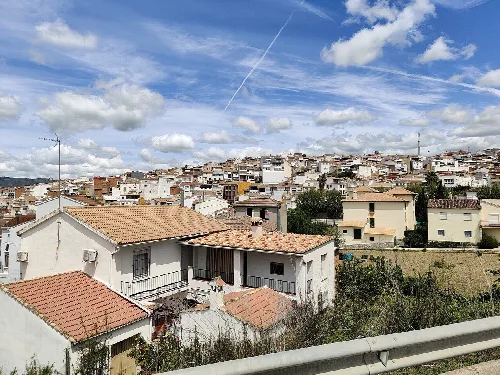 Ansicht von weißen Häusern und Himmel mit Wolken und Kondensstreifen in Castillo de Locubín.