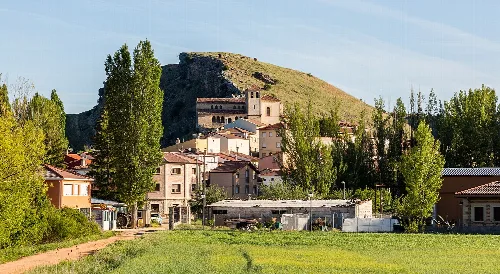 Vista de casas y un castillo en una colina en Abánades, Guadalajara.