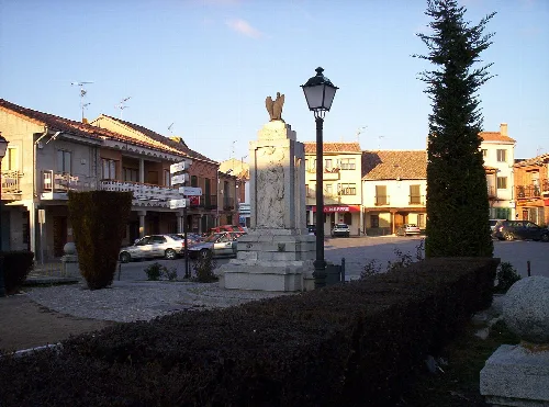Aguilafuente square with a statue and lamp post in the center.