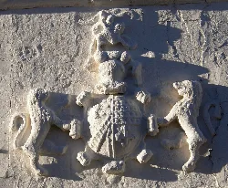 Escudo en relieve en la pared de piedra de La Almarcha.