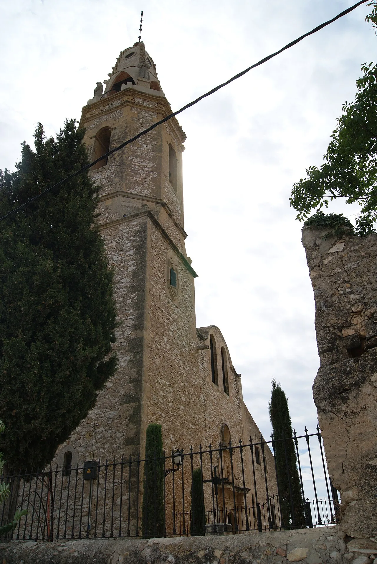 Ein Kirchturm mit Steinmauern und Bäumen in Creixell.