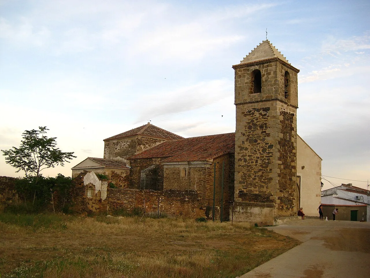 Steinige Kirche mit Turm und rotem Ziegeldach in Casas de Millán.