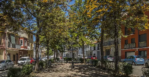 Platz mit Bäumen und Gebäuden in Castelló de la Ribera.