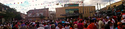 Multitud de personas en una plaza, celebrando con banderas y confeti en Pedrajas de San Esteban.