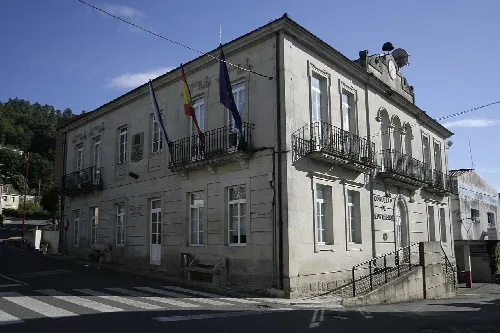 Zweistöckiges Gebäude mit Flaggen und Zugangsrampen.