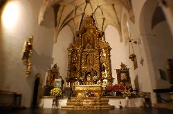 Interior de una iglesia con altar dorado y detalles religiosos en Mirabel.