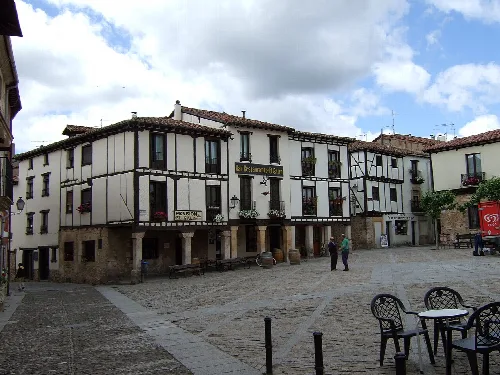 Covarrubias Plaza Mayor with white houses and wood, on a cloudy day.