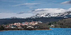 Vista del pueblo de Legutiano junto al embalse Urrunaga y montañas nevadas.