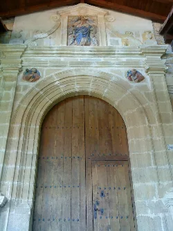 Church facade with stone arch and sculptures.