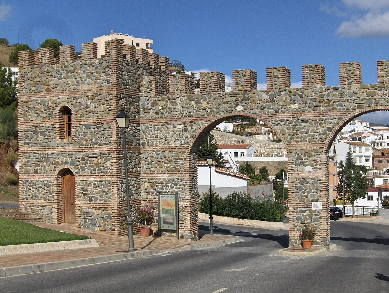 Puerta de piedra con arco de ladrillo en la muralla de Moclinejo.