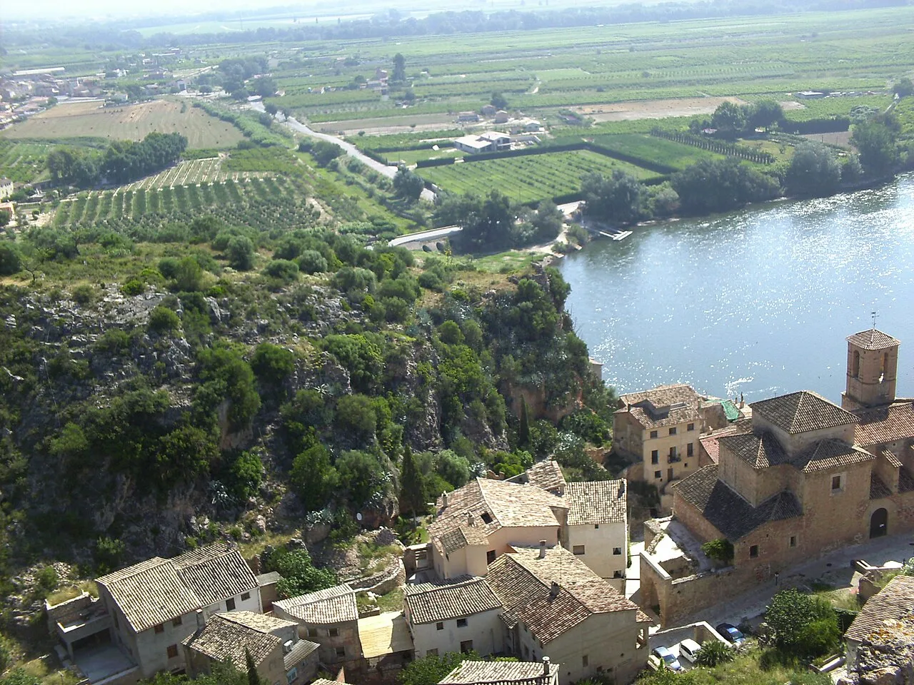 Aerial view of Miravet's old town with stone houses and river.