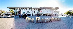 Modern facade of Fira Barcelona with people and large letters saying 'Fira Barcelona'.
