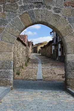 Steinbogen, der zu einer gepflasterten Straße in Bonilla de la Sierra führt.