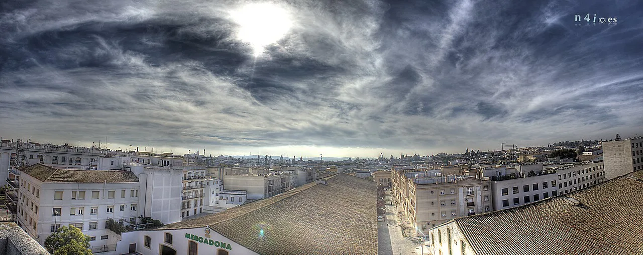 Panoramablick auf die Stadt mit Gebäuden und bewölktem Himmel.