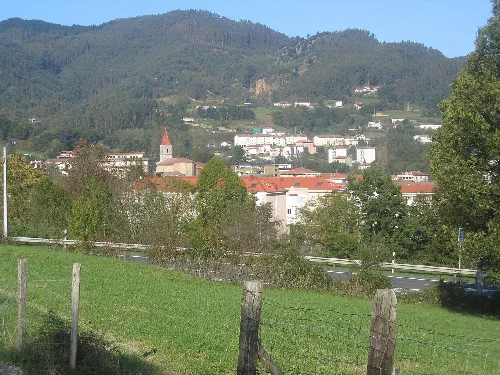 Paisaje de Sopuerta con colinas, árboles y edificios en la distancia.
