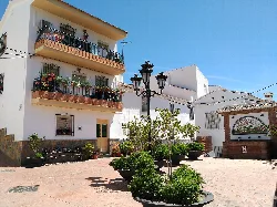 Square with benches, plants, and a lamppost in Totalán, Málaga.