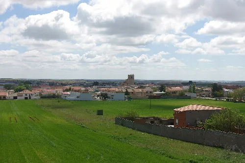 Panoramablick auf Los Hinojosos mit Burg und grünen Feldern.