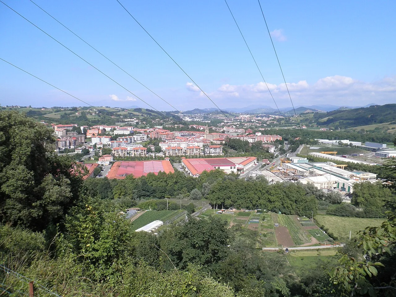 Vista panorámica de Usúrbil desde Urdaiaga con vegetación y construcciones.