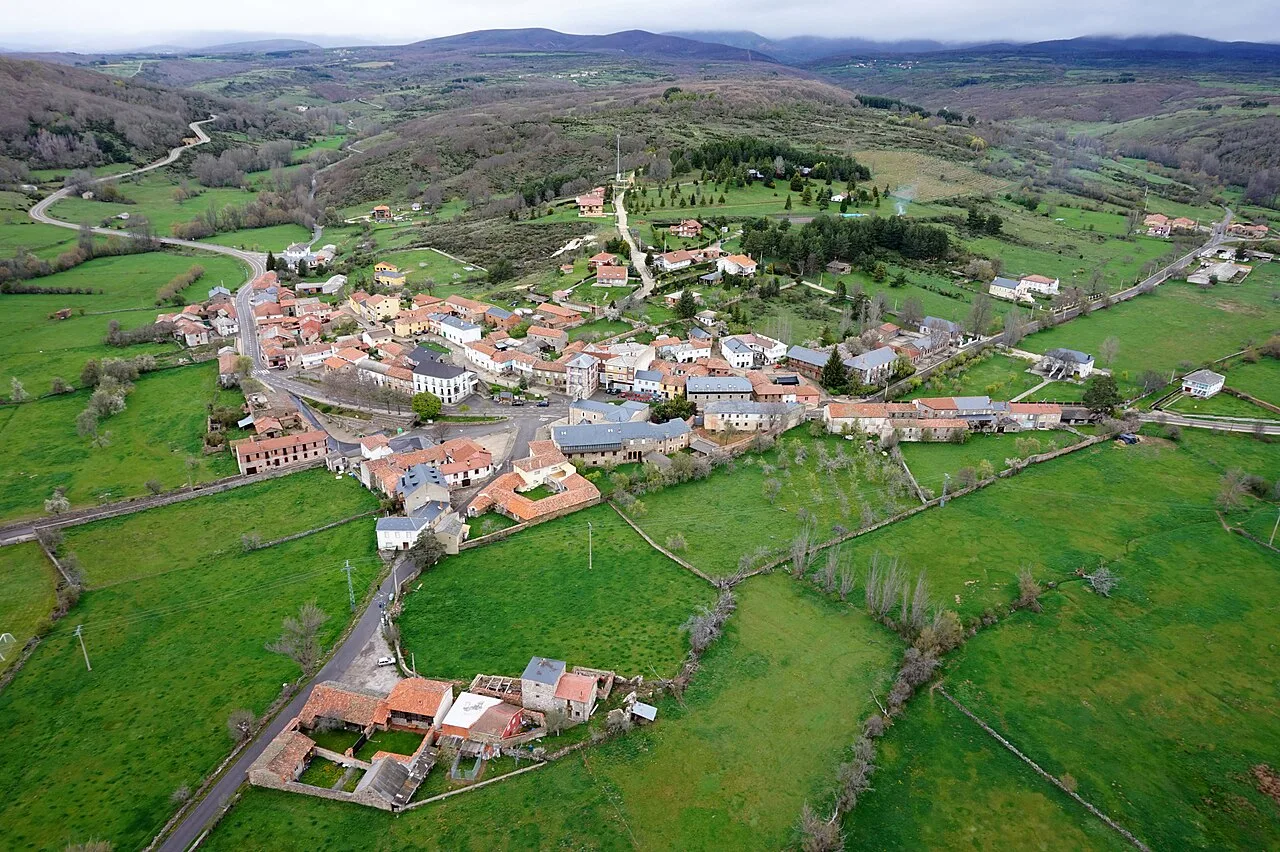 Aerial view of Riello from the south with houses and green fields.