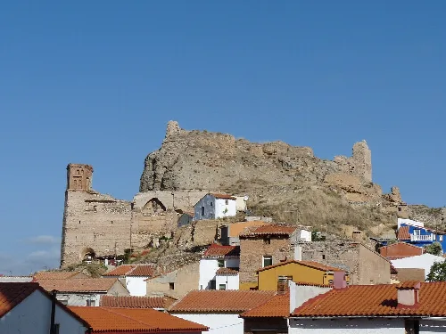 Castle ruins and church in Maluenda, with red-tiled houses.