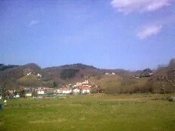 Ländliche Landschaft mit Hügeln, Häusern und blauem Himmel in Vera de Bidasoa, Navarra.