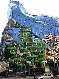 Modern building with irregular glass panels and reflections in Bilbao.