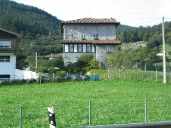 Asotegi Tower in Markina, Vizcaya, with fields and trees.