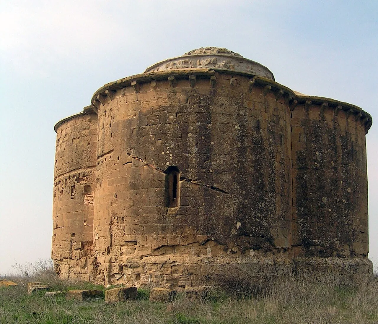 Se trata de los restos de la iglesia de un antiguo convento de
mercedarios que hubo en el lugar desde 1264.
El único vestigio conservado es la cabecera trebolada de la citada
iglesia y el arranque del primer tramo de la nave. El esquema
de la cabecera es realmente novedoso y remite a precedentes
orientales.
Partiendo de un espacio central cuadrado, se abren en tres de
sus lados ábsides semicirculares de igual tamaño, cumpliendo
el oriental la función de capilla mayor, mientras que en el lado
occidental se abre el primer tramo de la nave.
Cada ábside aparece cubierto con una bóveda de cuarto de esfera,
mientras que el espacio central presenta una gran cúpula
semiesférica sobre trompas de ángulo. El pequeño espacio
conservado del primer tramo de la nave aparece cubierto por
una bóveda de cañón que arranca de la imposta que recorre
todo el perímetro de la superficie conservada.
La fábrica es de sillar e interiormente destaca por la presencia
de restos de pintura mural de estilo gótico lineal, pudiéndose
identificar aún algunos motivos como un Pantocrátor rodeado
del Tetramorfos, la Entrada de Jesucristo en Jerusalén, la Última
Cena, la Oración en el Huerto, varias figuras de santos,
bandas de zig-zag, etc.

Entorno