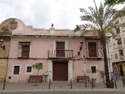 Two-story building with balcony and barred windows in Puebla de Vallbona.