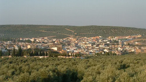 Panoramablick auf Ibros mit Olivenhainen und Hügeln im Hintergrund.