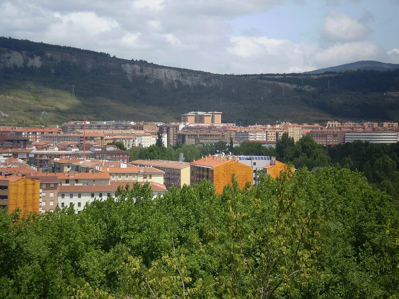 Aussicht auf Ansoáin mit Bergen und Stadtvierteln im Hintergrund.
