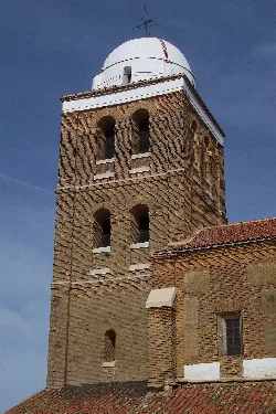 Torre de ladrillo con ventanas y cúpula blanca en San Román de la Cuba.