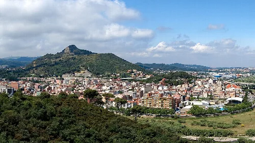 Panoramic view of Montcada i Reixac with mountains and city in the background.