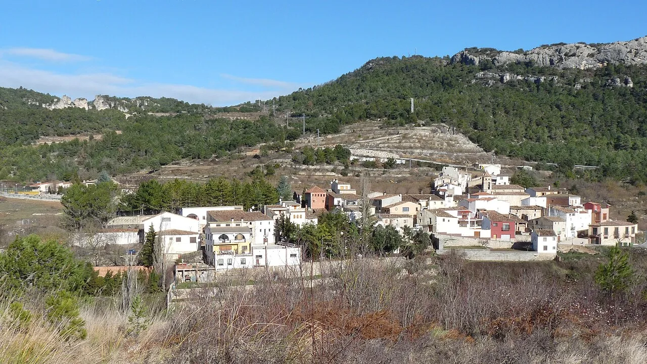 Vista de casas en un pueblo en una zona montañosa con vegetación.