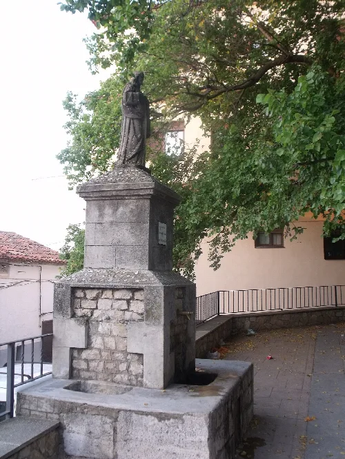 Steinbrunnen mit religiöser Statue in Villar de Canes.