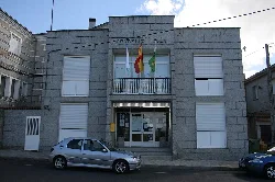 Toén town hall building with flags on the facade.
