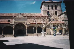 Stone church facade with tower and leafless trees in Piedrahíta.