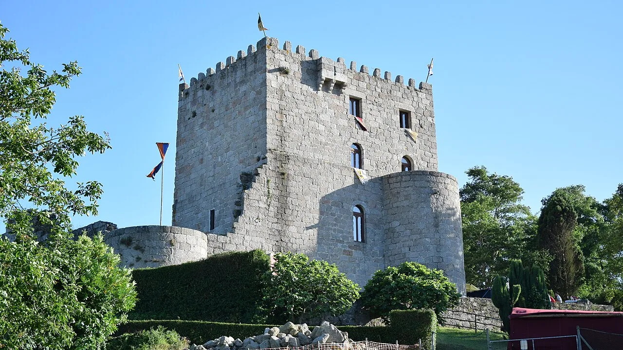 Steinernes Schloss mit Türmen und Mauern in einer grünen Umgebung in Alfoz.