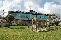 Modern building with glass windows and stone structures in the foreground.