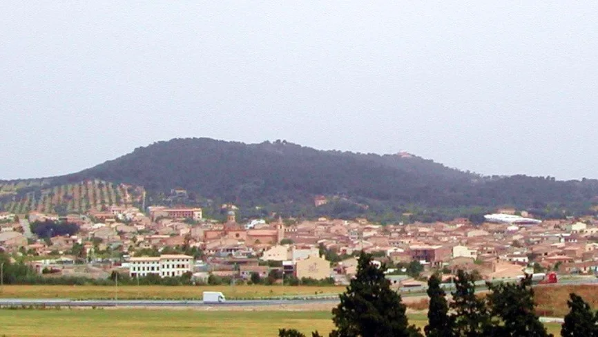 Vista de un pueblo con colinas verdes en el fondo en Baleares