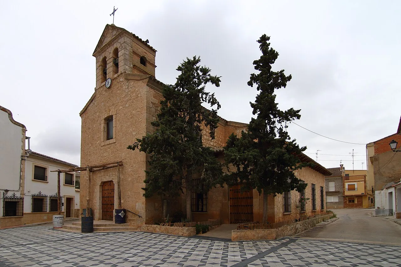 Stone church with tower and trees in Villarta, Cuenca.