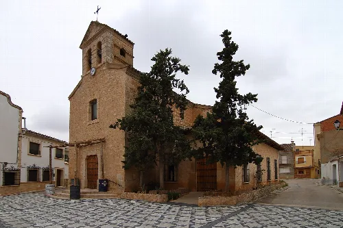 Steinernen Kirche mit Turm und Bäumen in Villarta, Cuenca.