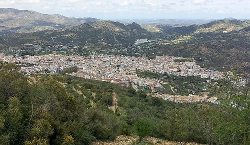 Panoramablick auf Priego de Córdoba mit Bergen und Vegetation im Vordergrund.