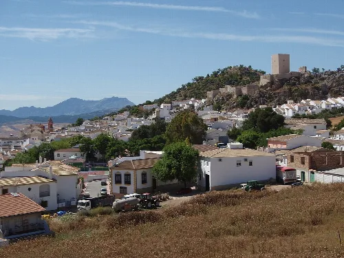 Panoramablick auf Cañete la Real mit weißen Häusern und einer Burg auf dem Hügel.