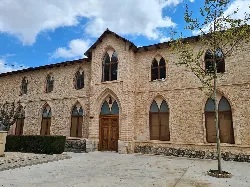 Stone building with Gothic windows and wooden door in Ibi.