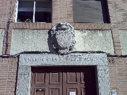 Puerta de una iglesia con escudo y grabados en piedra.